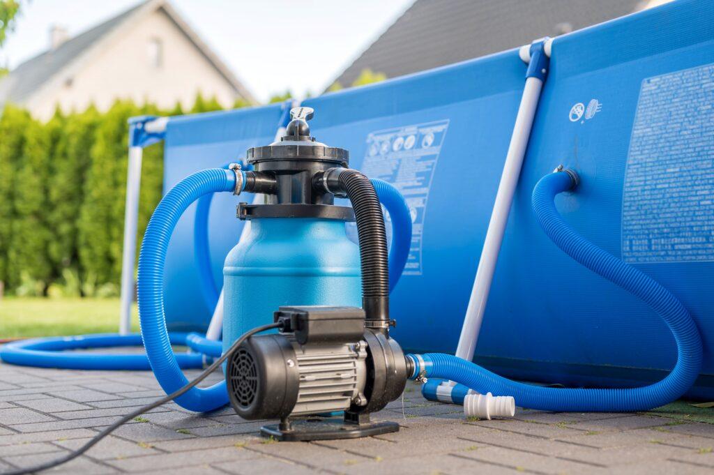 Blaue Sandfilteranlage neben einem Pool im Garten