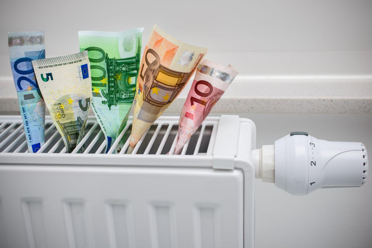 Euro-Geldscheine stecken in einem Heizkörper – hohe Heizölpreise in Brandenburg und mögliche Einsparpotenziale beim Heizen