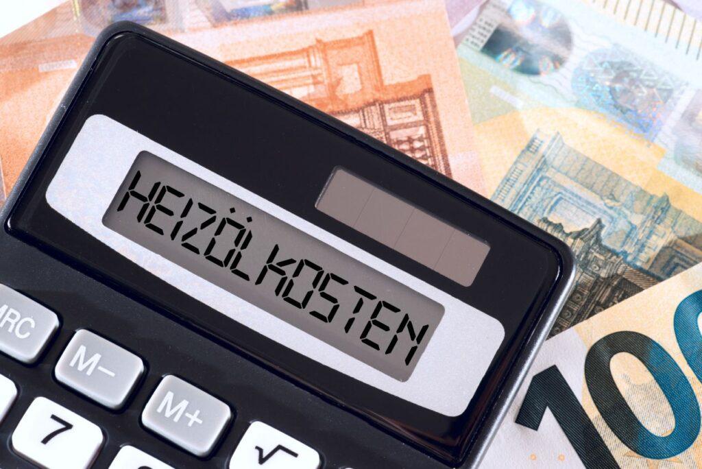Taschenrechner mit Anzeige Heizölkosten liegt auf Euro-Geldscheinen –Heizölpreise Brandenburg und regionale Preisberechnung