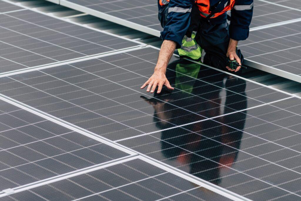 Techniker installiert Solarmodule auf Dach | PV Großhandel