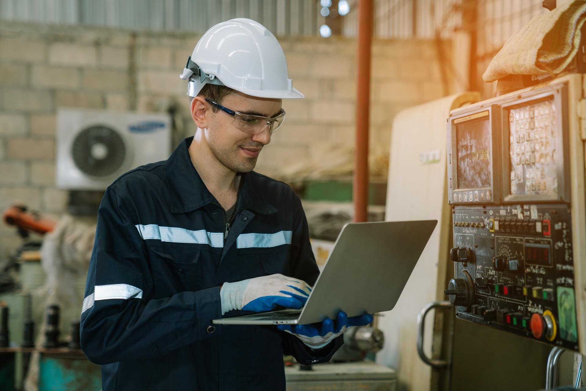 Ingenieur arbeitet mit Laptop an digitaler Produktionsanlage | Entkalkungsanlage